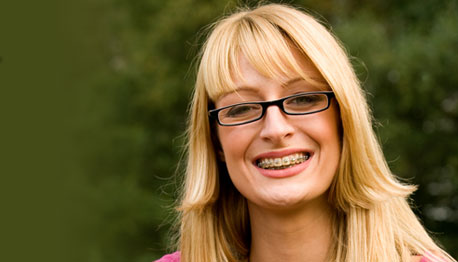 adult woman with braces smiling outdoors