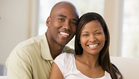 smiling adult couple on couch