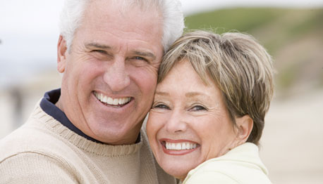 smiling adult couple embracing outside